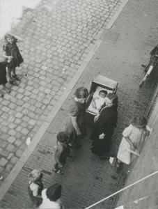 876883 Afbeelding van twee vrouwen die met een kinderwagen in de rij staan voor het Klooster Genazzano van de Zusters ...